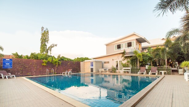 A swimming pool with lounge chairs and a building in the background. - OYO 824 Valida Resort (Pattaya)