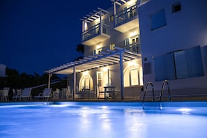 Un immeuble à plusieurs étages doté d’une piscine, d’un espace extérieur aménagé et de balcons.