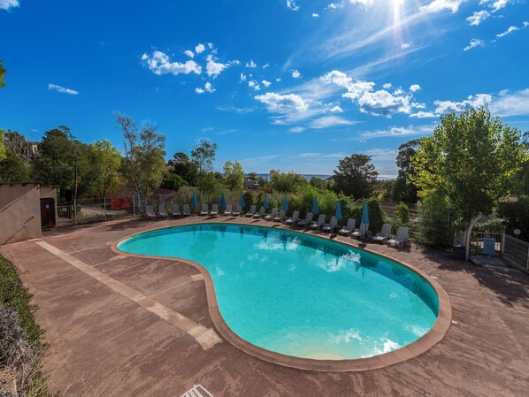 季节性开放的室外游泳池，10:00 至 19:00 开放，池畔遮阳伞，日光浴躺椅