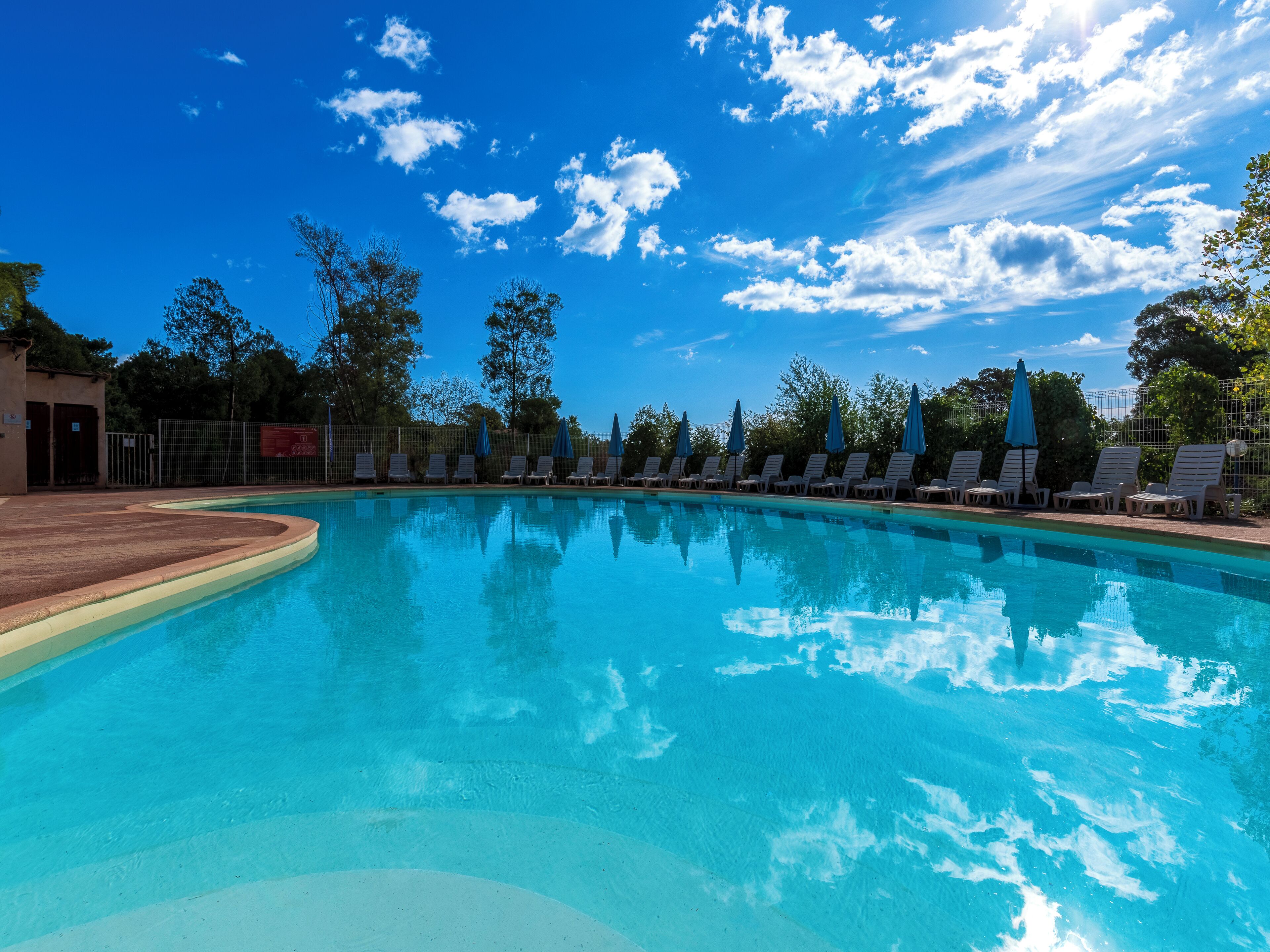 Een seizoensgebonden buitenzwembad en parasols bij het zwembad