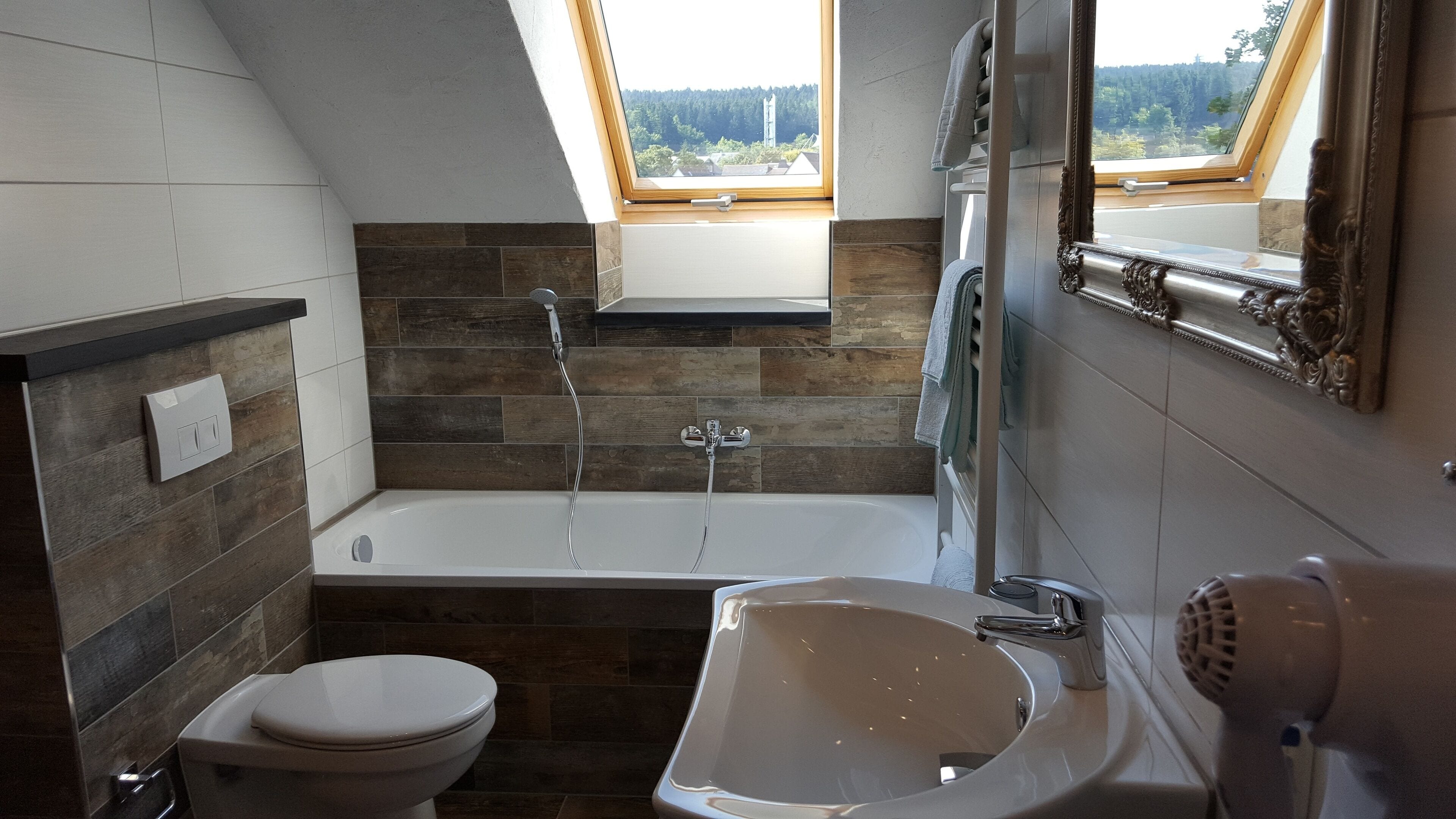 A modern bathroom with a bathtub, toilet, and sink.