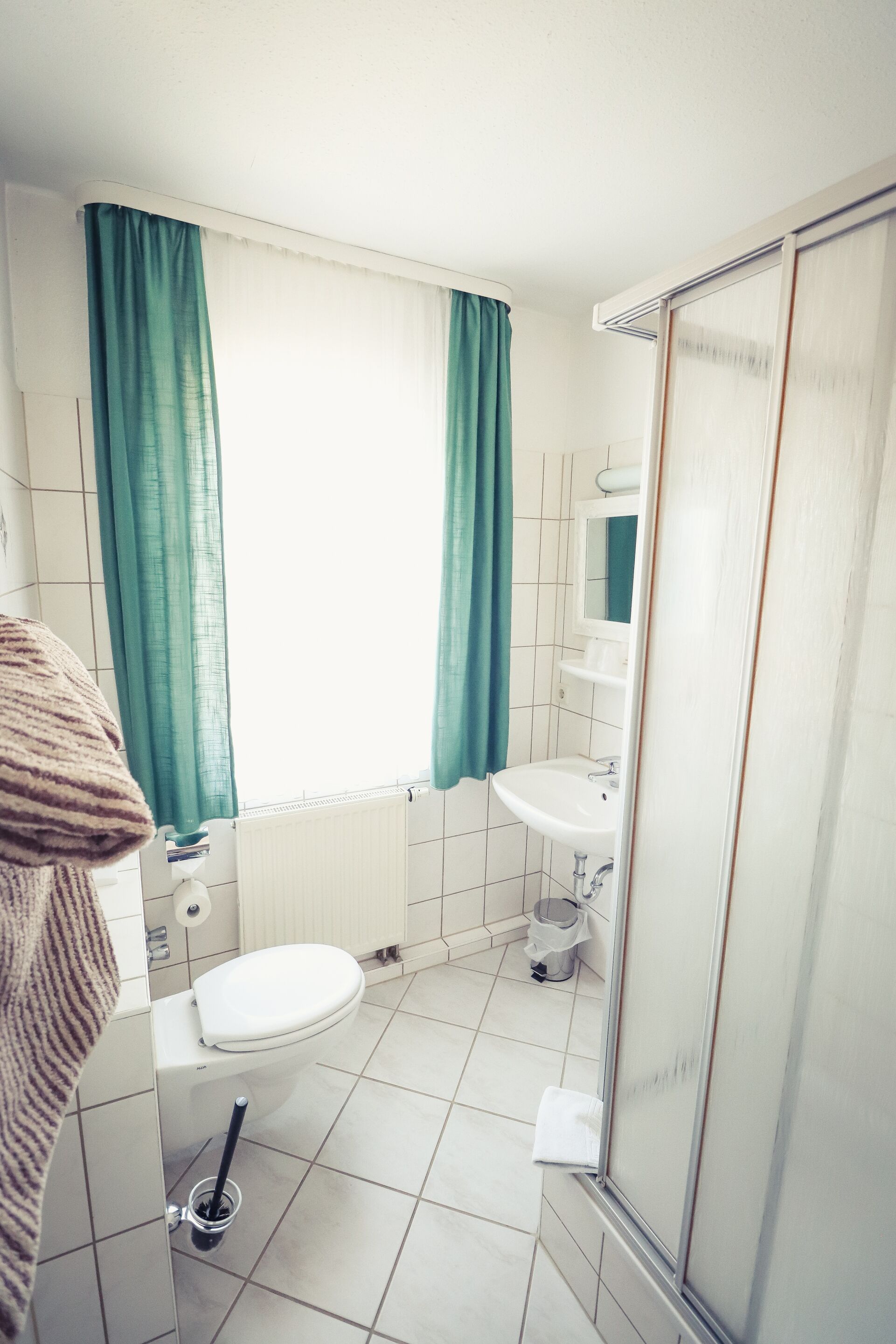 Une petite salle de bain avec des toilettes, un lavabo et une douche.