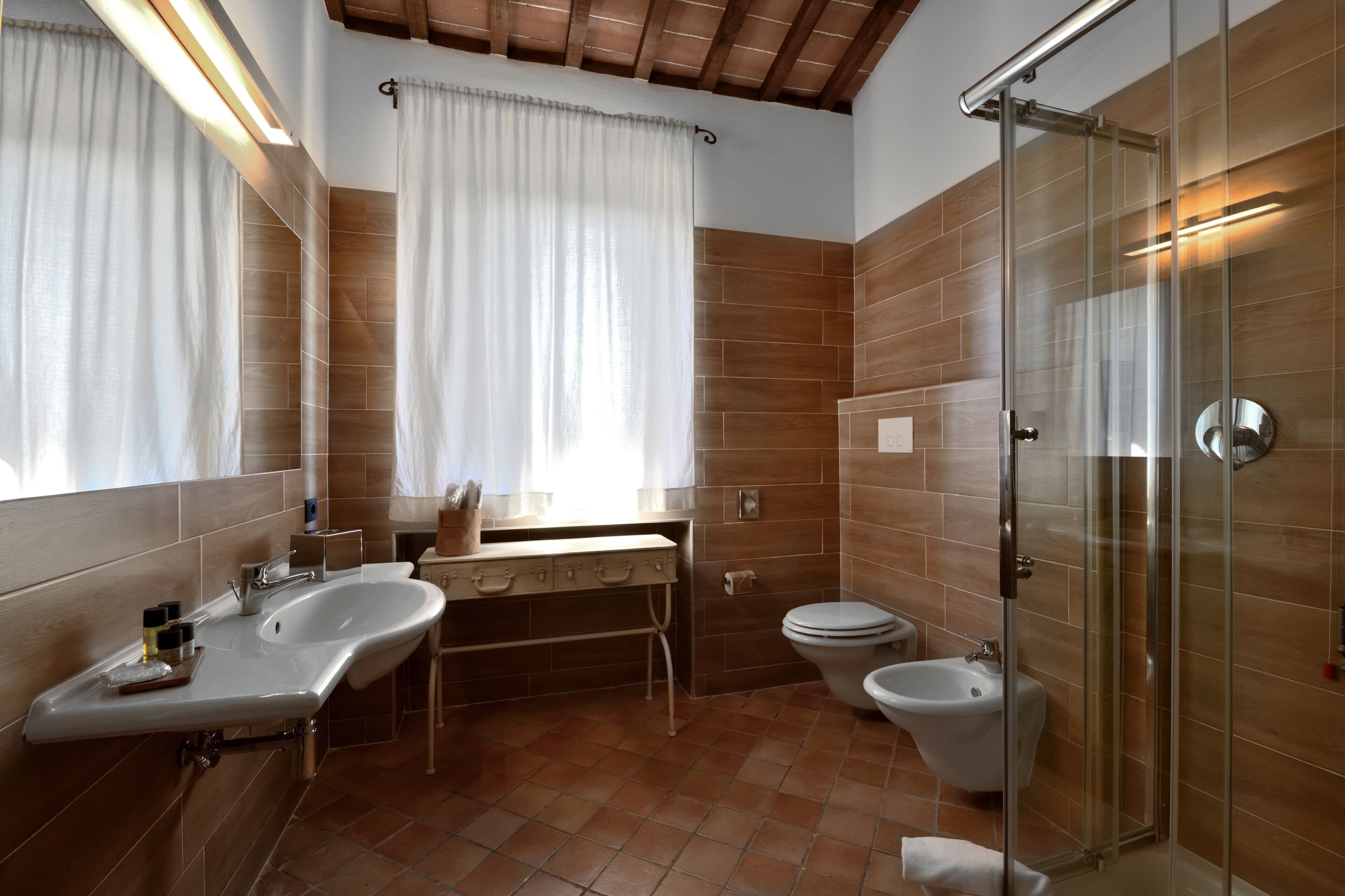 Un bany modern amb dutxa de vidre, un lavabo i un vàter.