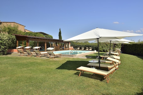 Una piscina al aire libre de temporada, sombrillas