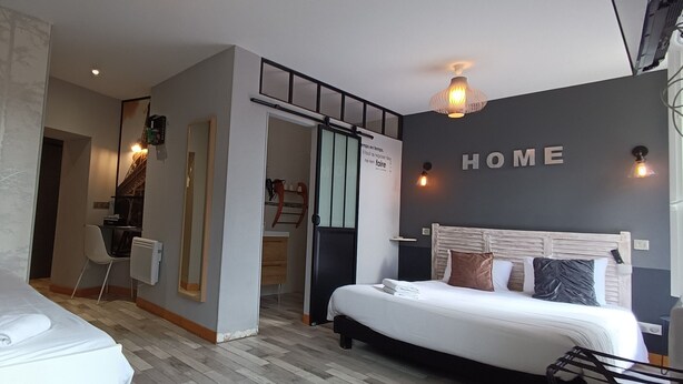 Una habitación de hotel moderna con dos camas, un espejo, un escritorio y un letrero con la palabra 'HOME' en la pared.