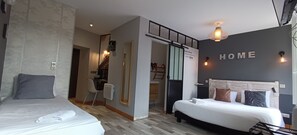 Una habitación de hotel moderna con dos camas, un espejo, un escritorio y un letrero con la palabra 'HOME' en la pared.