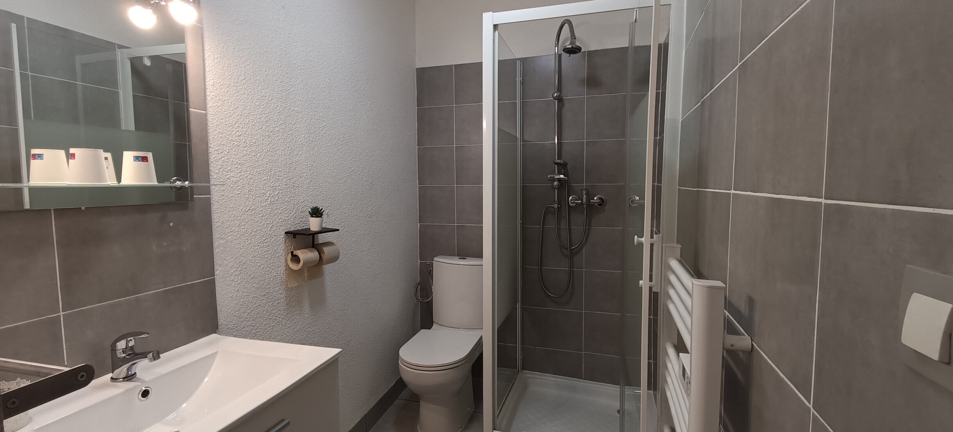 Un bagno moderno con doccia, WC e lavandino.