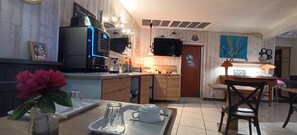 Una cocina moderna con microondas integrado, cafetera y televisor de pantalla plana.