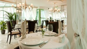A dining area with round tables, chairs, and chandeliers. - Earth and People Hotel & Spa (Sofia)