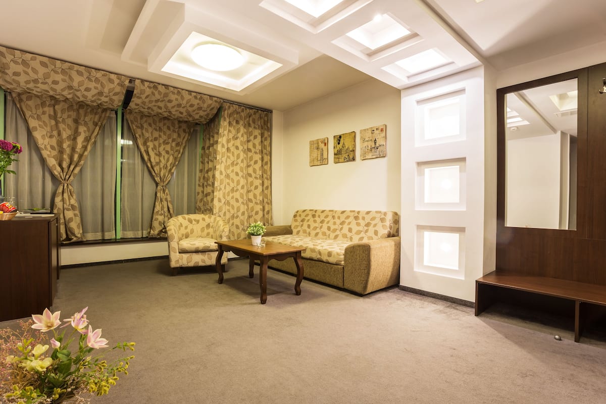 A living room with a sofa, a coffee table, and a mirror.