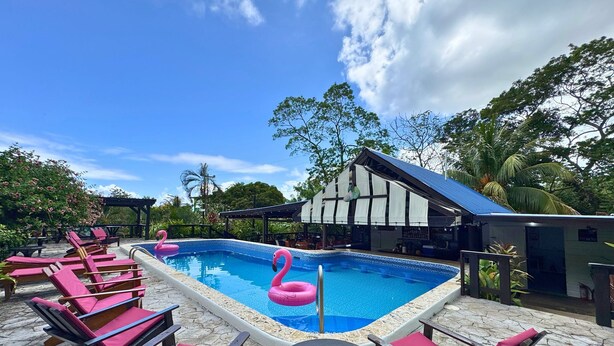 Un espace piscine avec des chaises longues et une petite table.