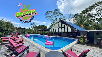 Una piscina al aire libre, sillones reclinables de piscina