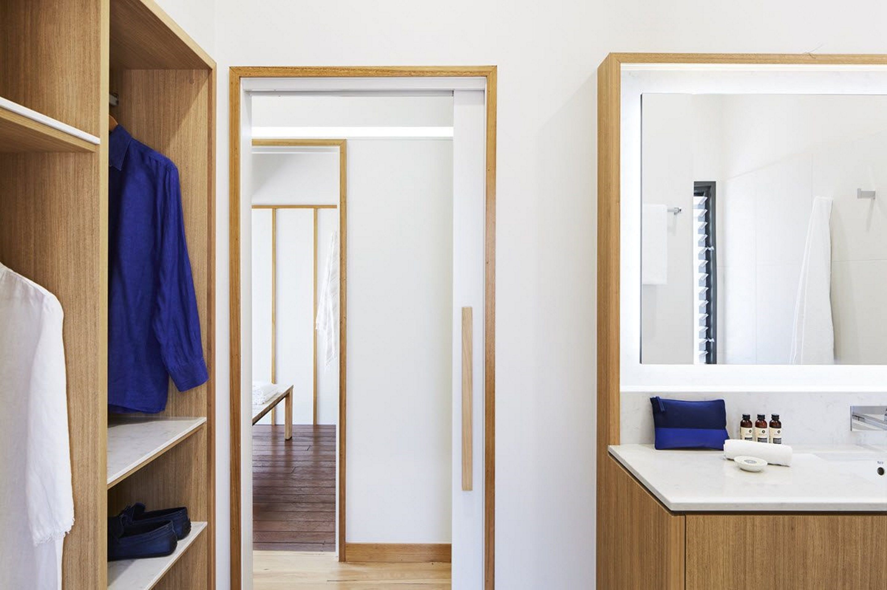A modern bathroom with a large mirror, a sink, and a shower area.