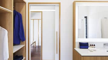 A modern bathroom with a large mirror, a sink, and a shower area.