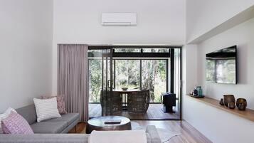 A modern living room with a sofa, a coffee table, and a TV mounted on the wall.