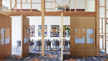 A modern dining area with wooden partitions, a blue floral carpet, and a view of the cityscape.