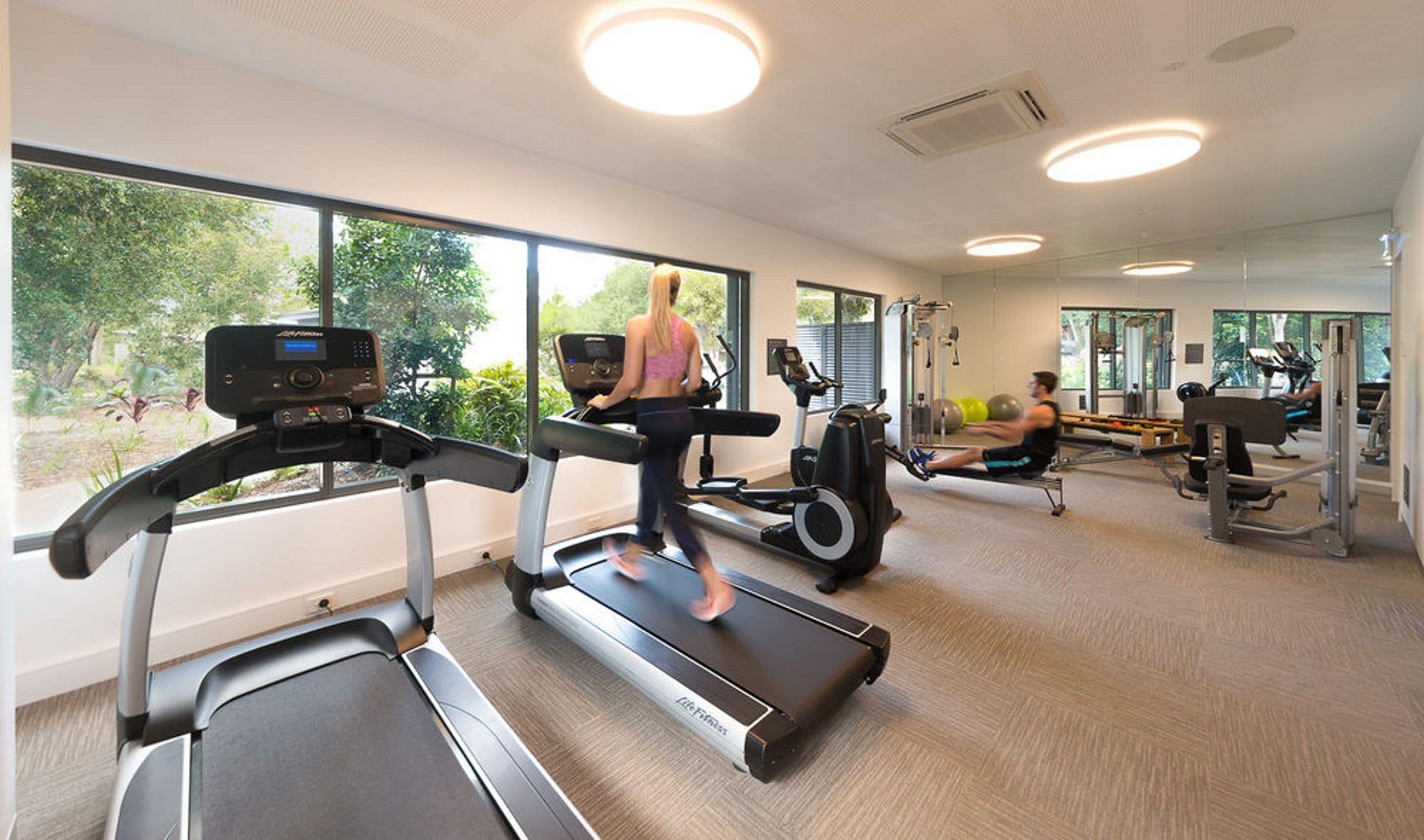 A gym with treadmills, a rowing machine, and exercise equipment.