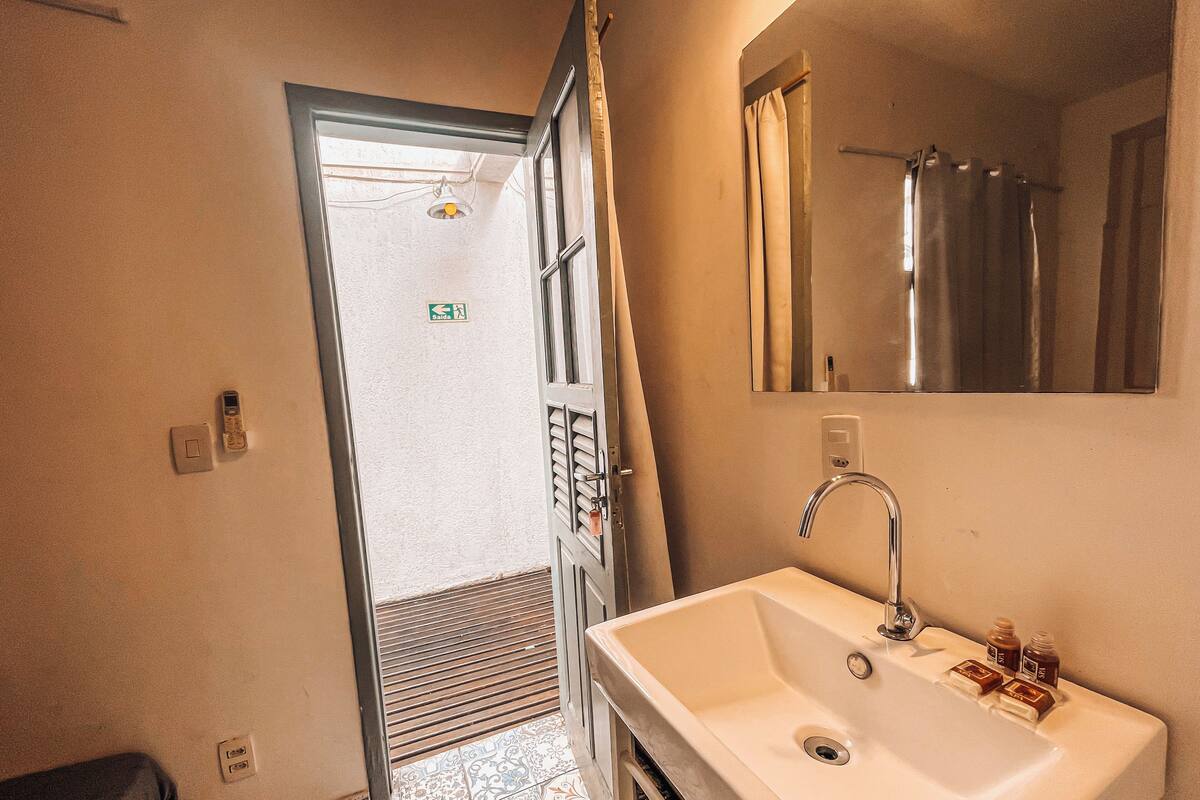 A bathroom with a sink, mirror, and shower.