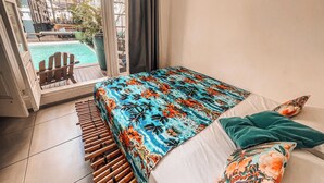 A bedroom with a bed, a view of an outdoor pool, and a balcony. - Casa Tuxi (Rio de Janeiro)