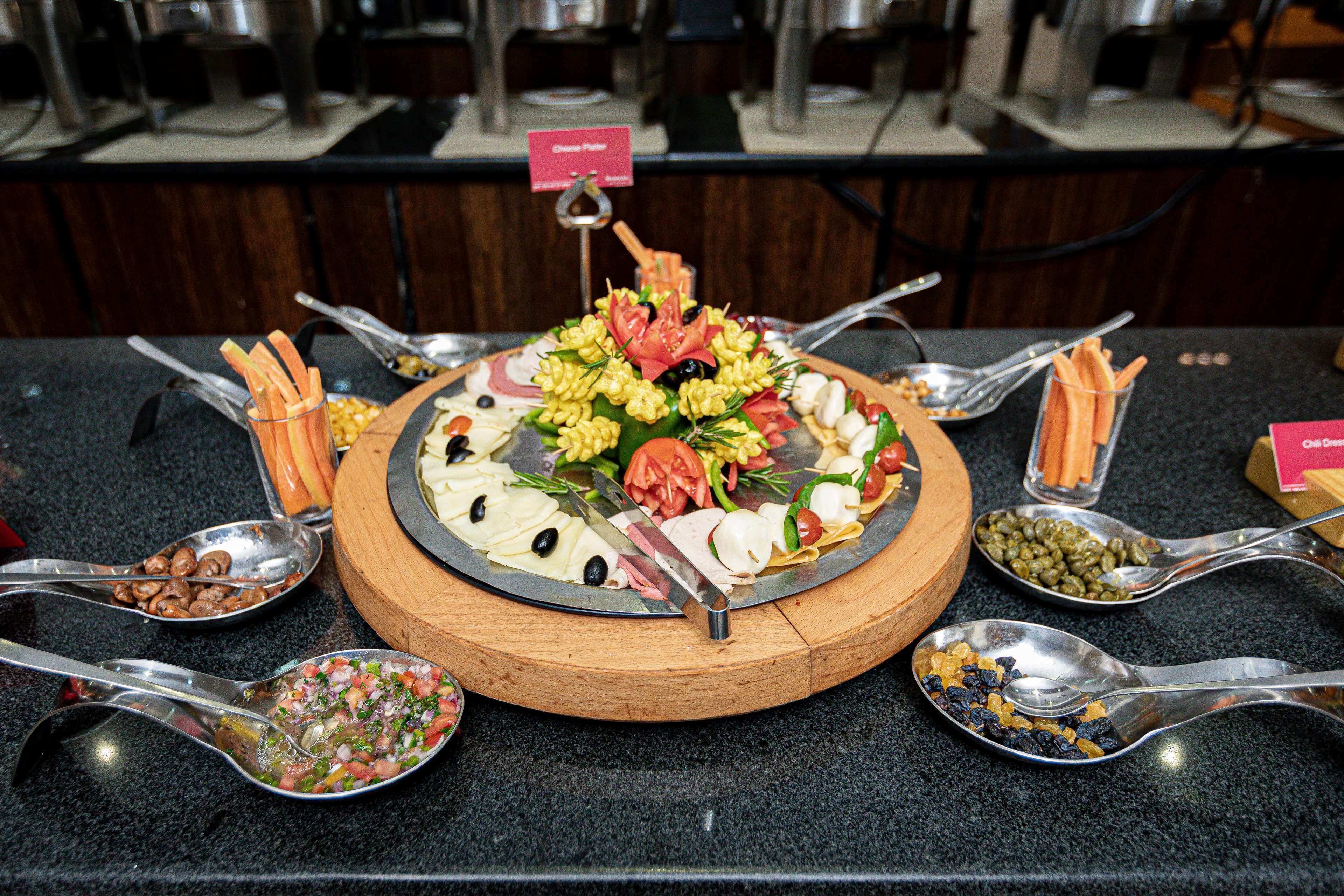 Una mesa de buffet con diversos alimentos y utensilios.