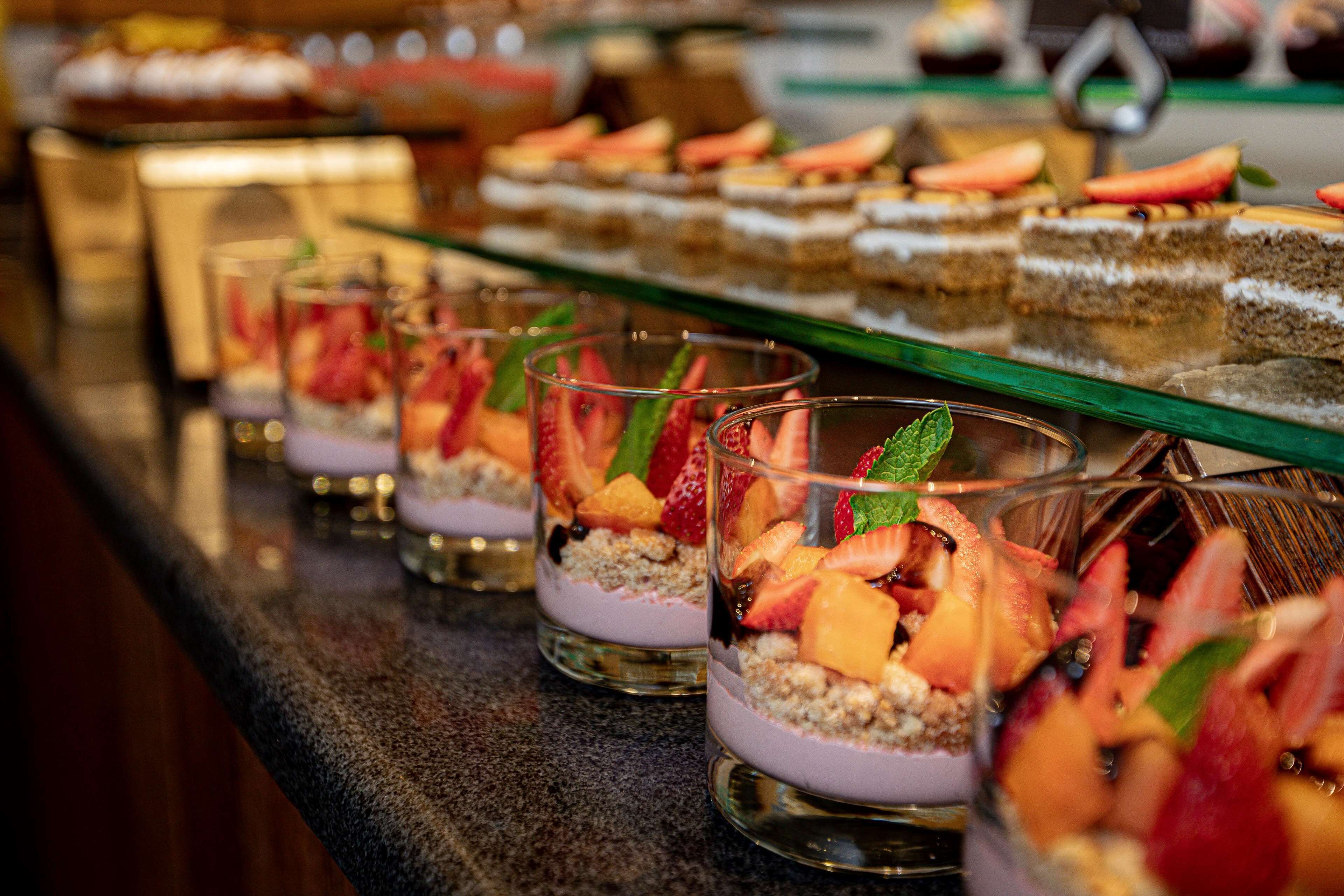Un bar à desserts proposant une variété de desserts garnis de fruits et un assortiment de gâteaux.