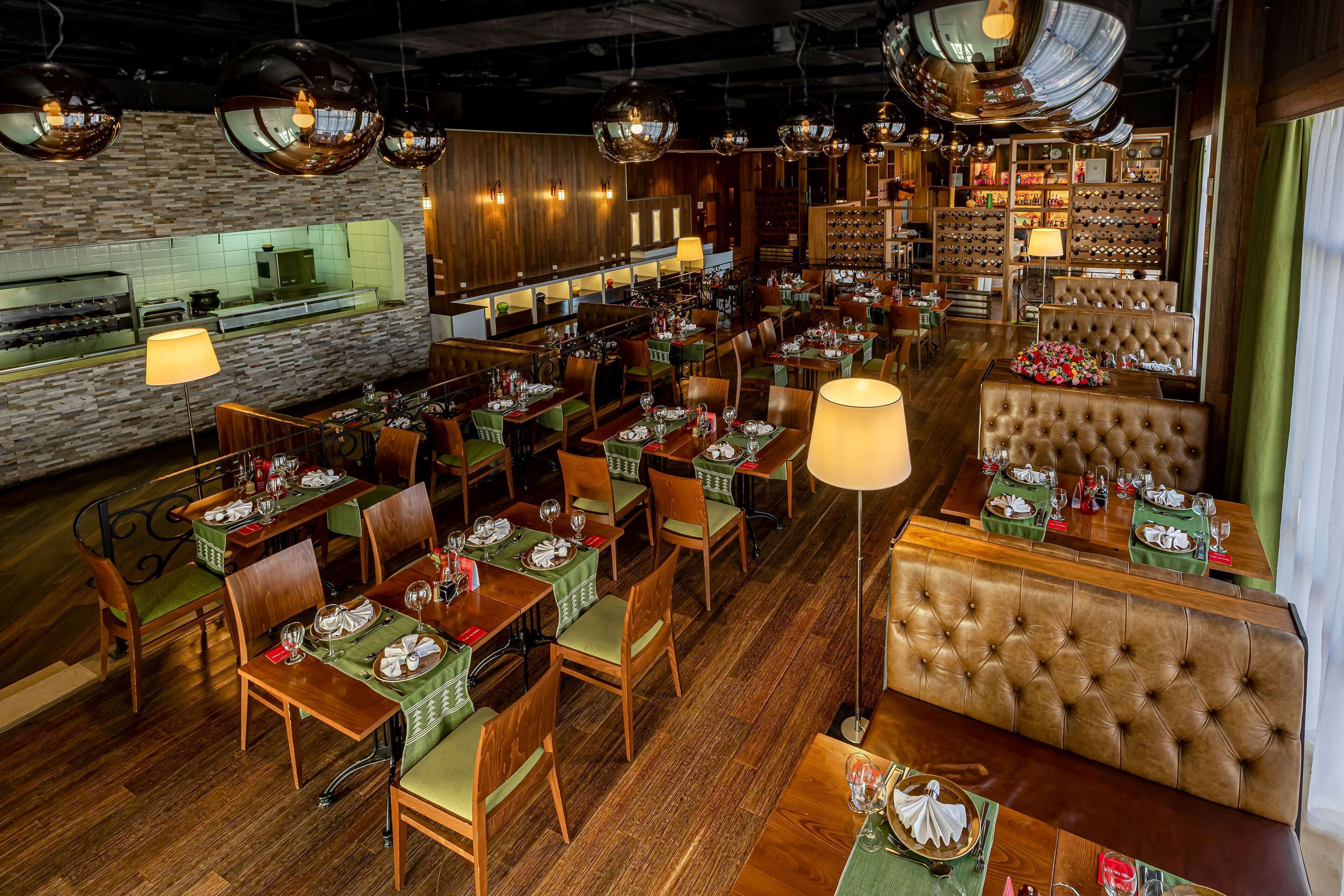 A restaurant with multiple dining tables, chairs, and a bar area.