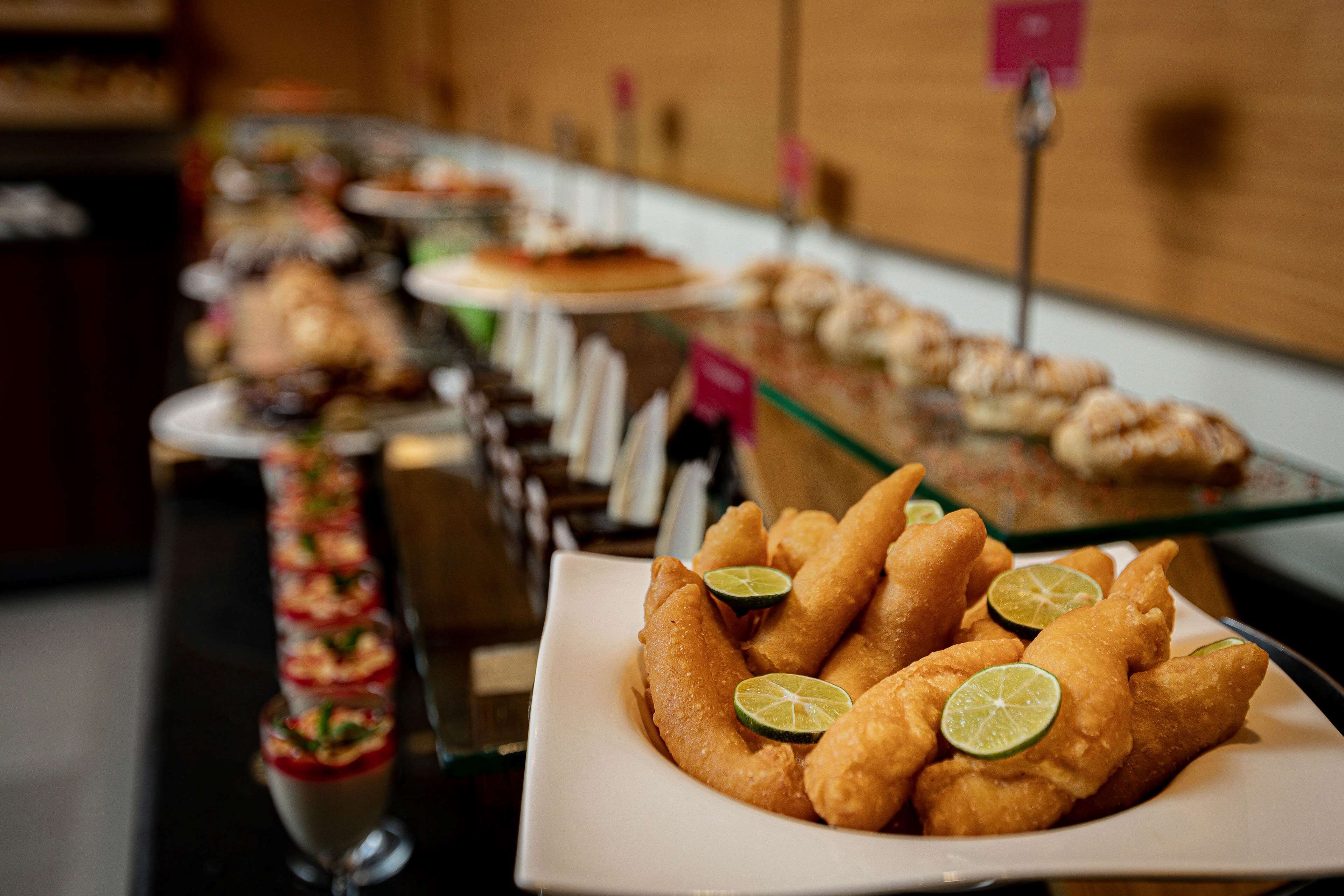 A buffet with various dishes including fried items and a dessert.