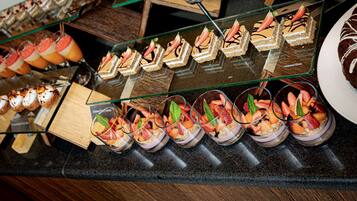 A variety of desserts displayed on a counter, including cakes and fruit-based desserts in glass cups.