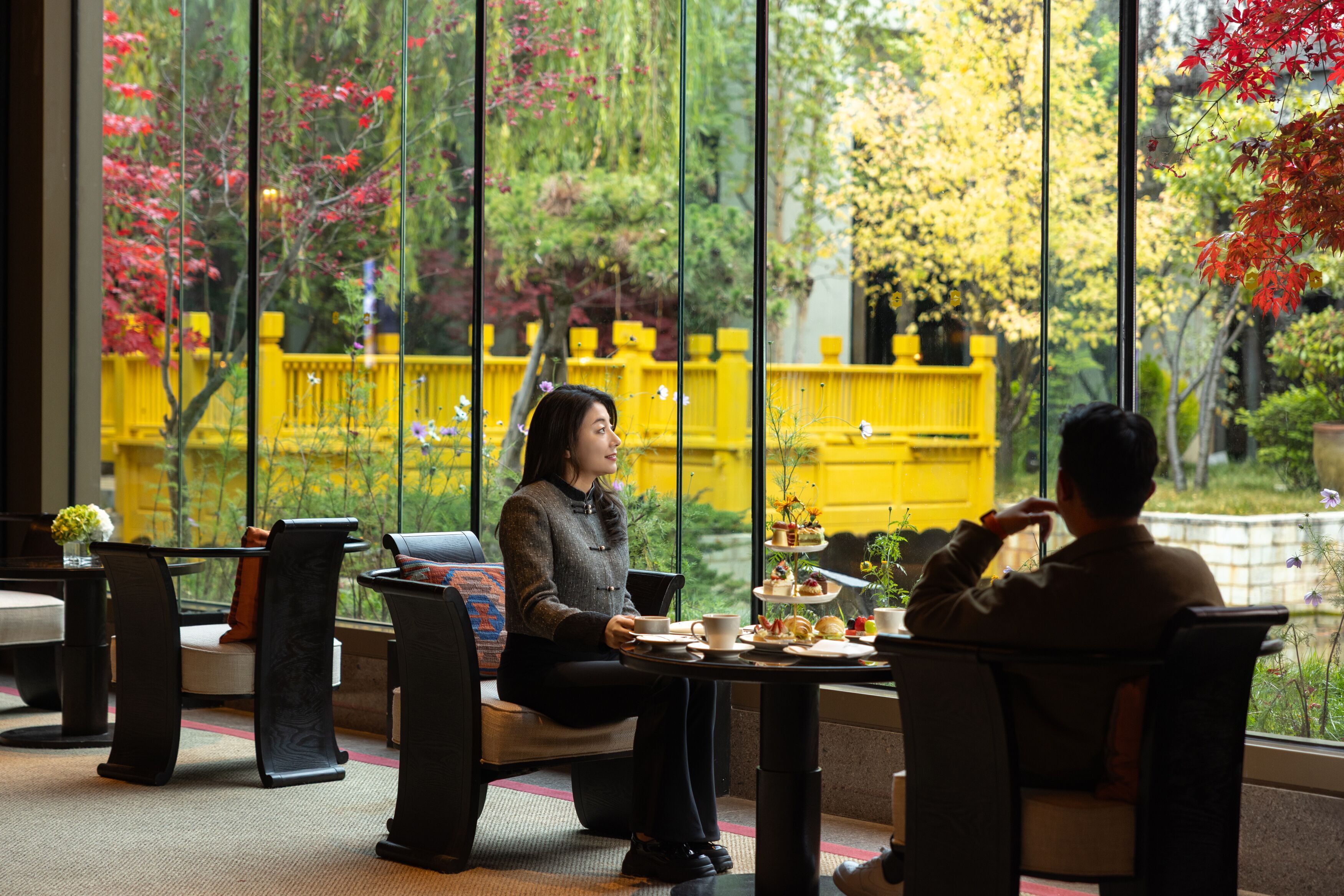 A cafe with a view of a yellow building and trees.