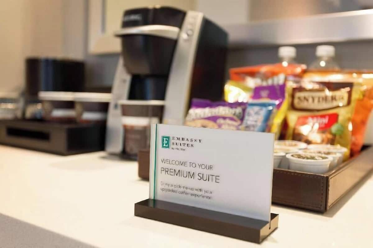 Une machine à café, un plateau de collations et une pancarte de bienvenue pour une suite de luxe.