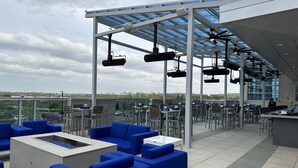A rooftop bar with blue seating, a bar area, and a view of the cityscape. - Embassy Suites by Hilton Kansas City Olathe (Olathe)