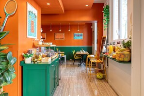 Un restaurante con un mostrador verde, sillas amarillas y una raqueta de tenis en la pared.