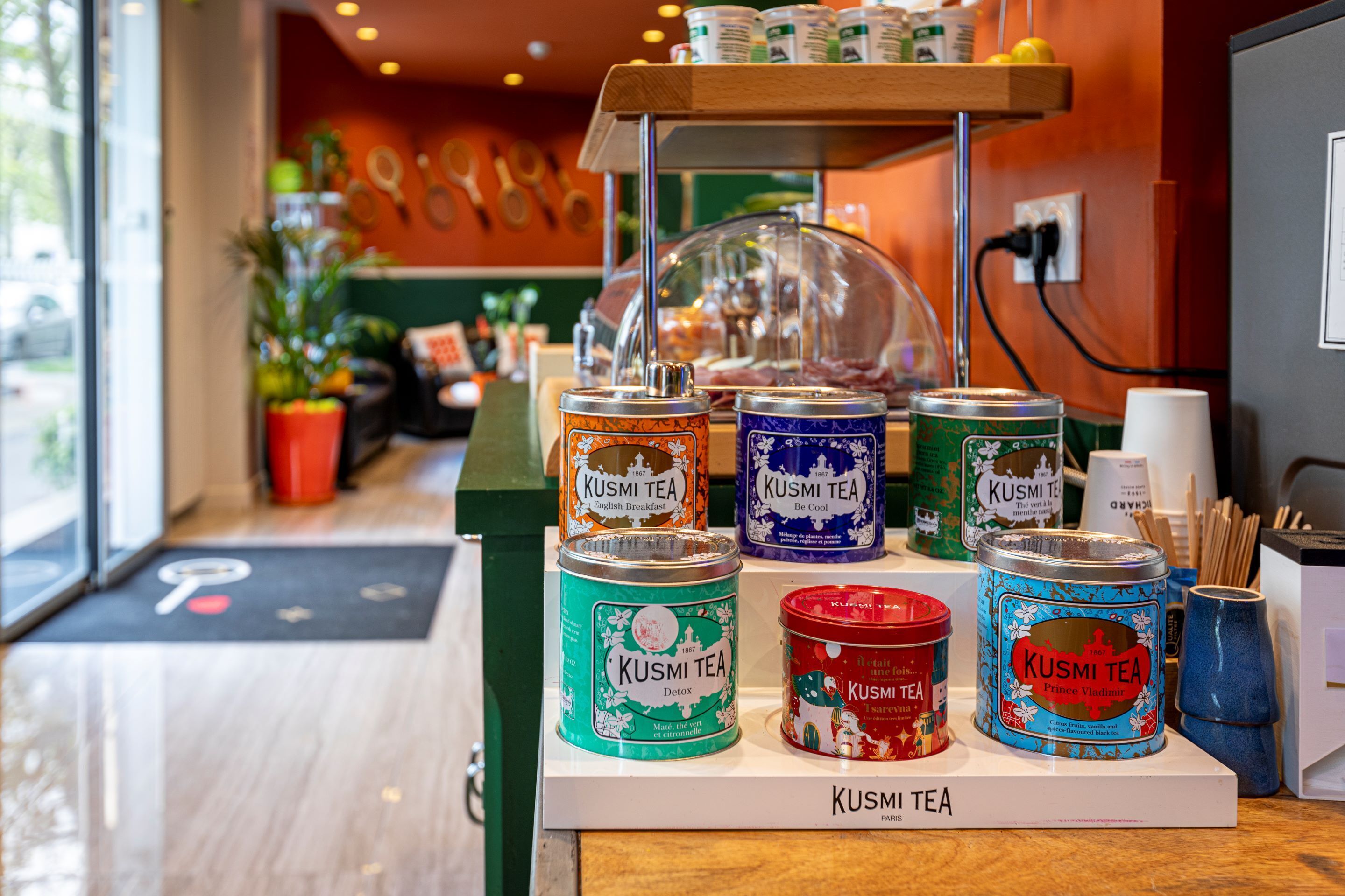 A display of various KUSMI TEA products in different flavors and packaging.
