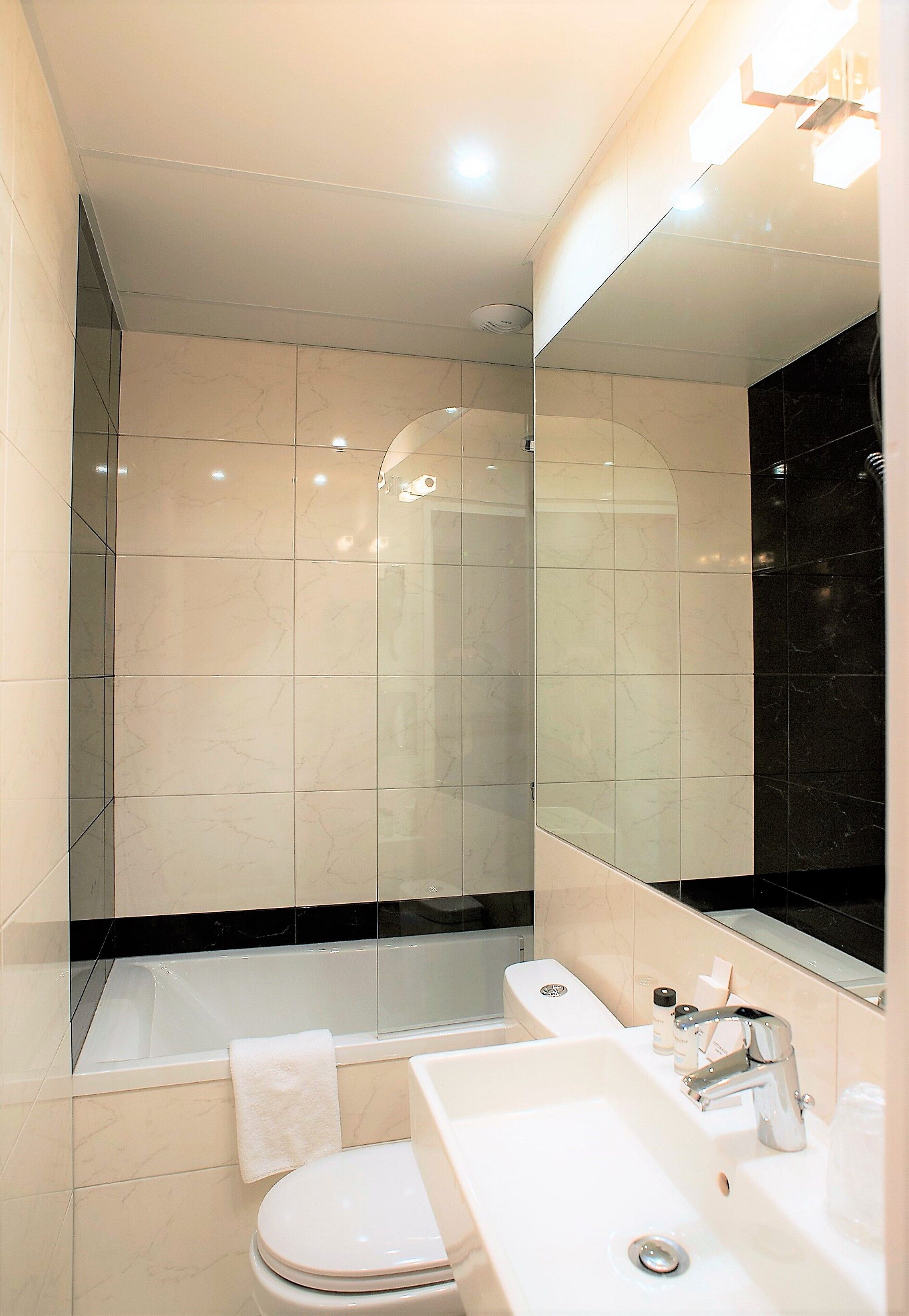A modern bathroom with a bathtub, toilet, and sink.