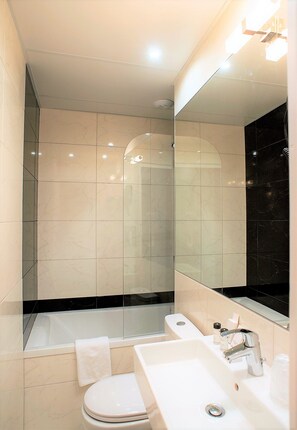 Un baño moderno con bañera, inodoro y lavamanos.