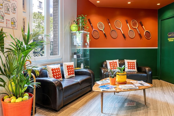 Un moderno salón con un sofá de cuero, una mesa de centro y una pared decorada con raquetas de tenis.