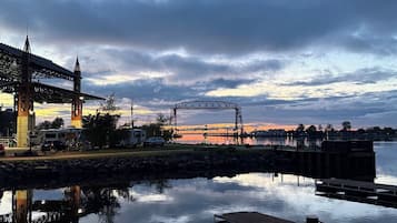 Vista al frente del agua con un puente, un muelle y una zona para vehículos recreativos.