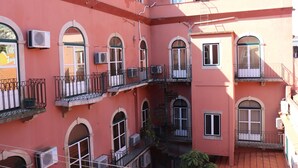 A multi-story building with arched windows and balconies, featuring air conditioning units and a tiled roof. - Belém Tejo - Setubalense (Lisbon)