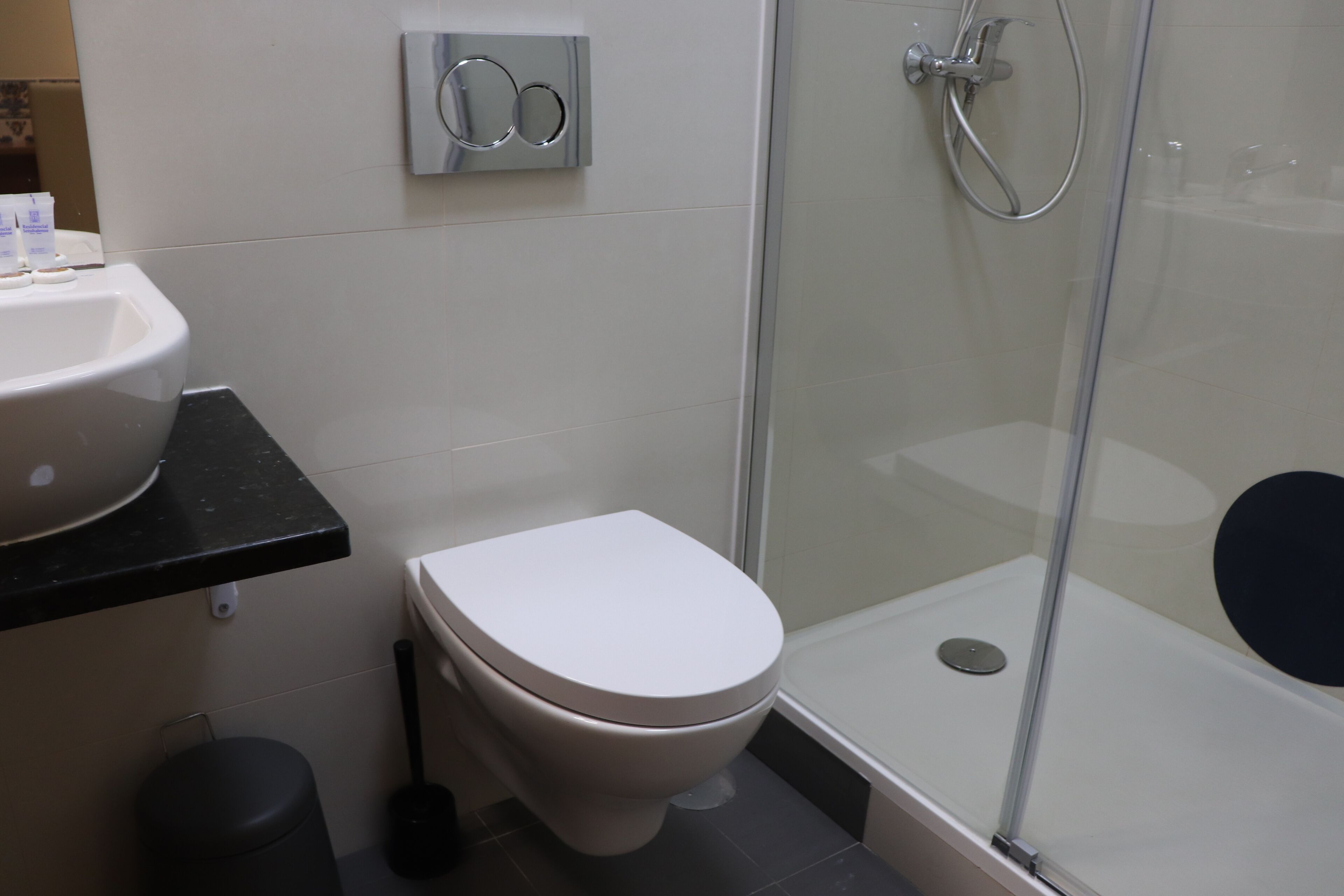 A bathroom with a toilet, sink, and glass-enclosed shower.
