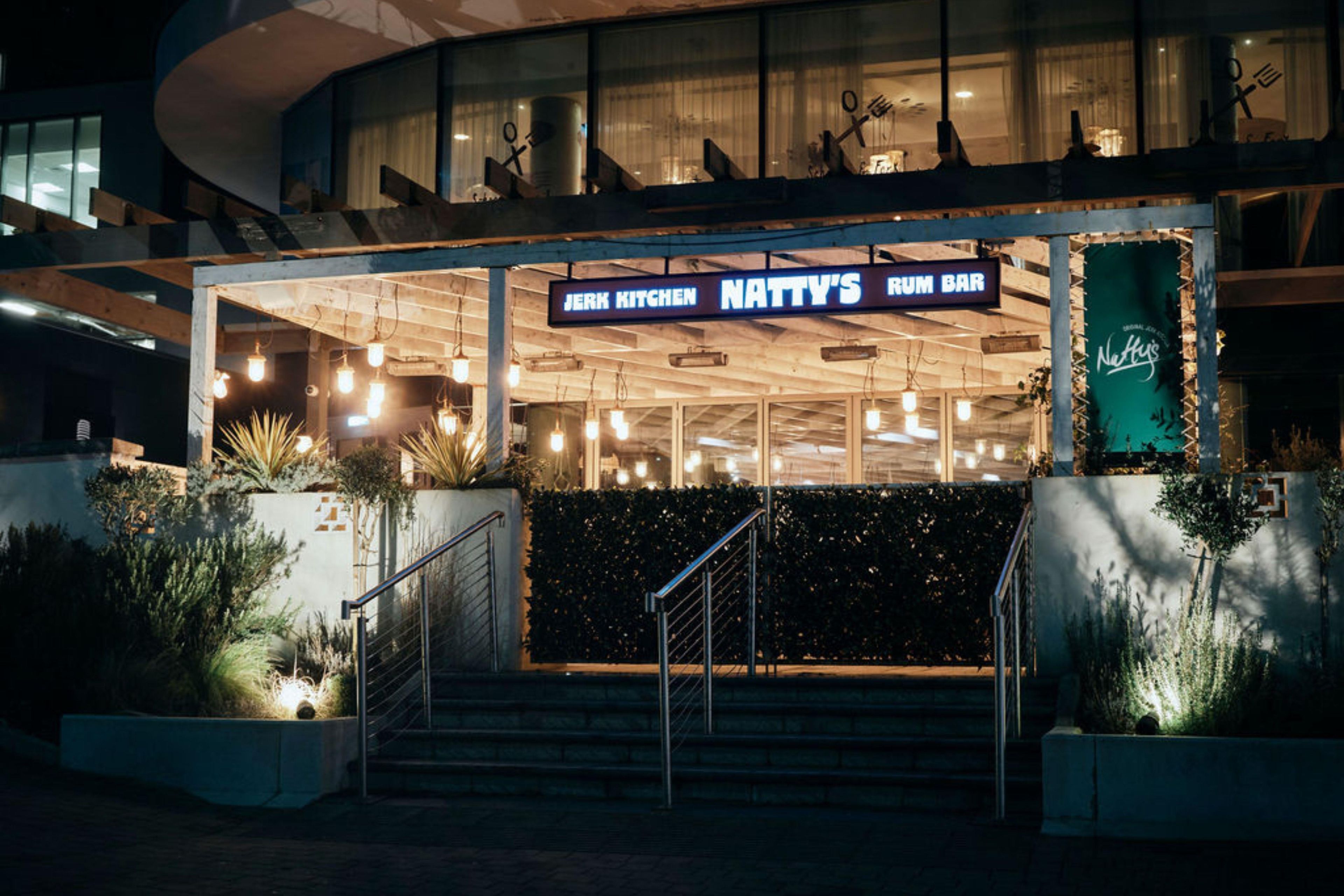 Un restaurant au design moderne, dont l’enseigne indique : « JERK KITCHEN NATTY’S RUM BAR ».