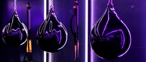 Tres sacos de boxeo colgando en un gimnasio.