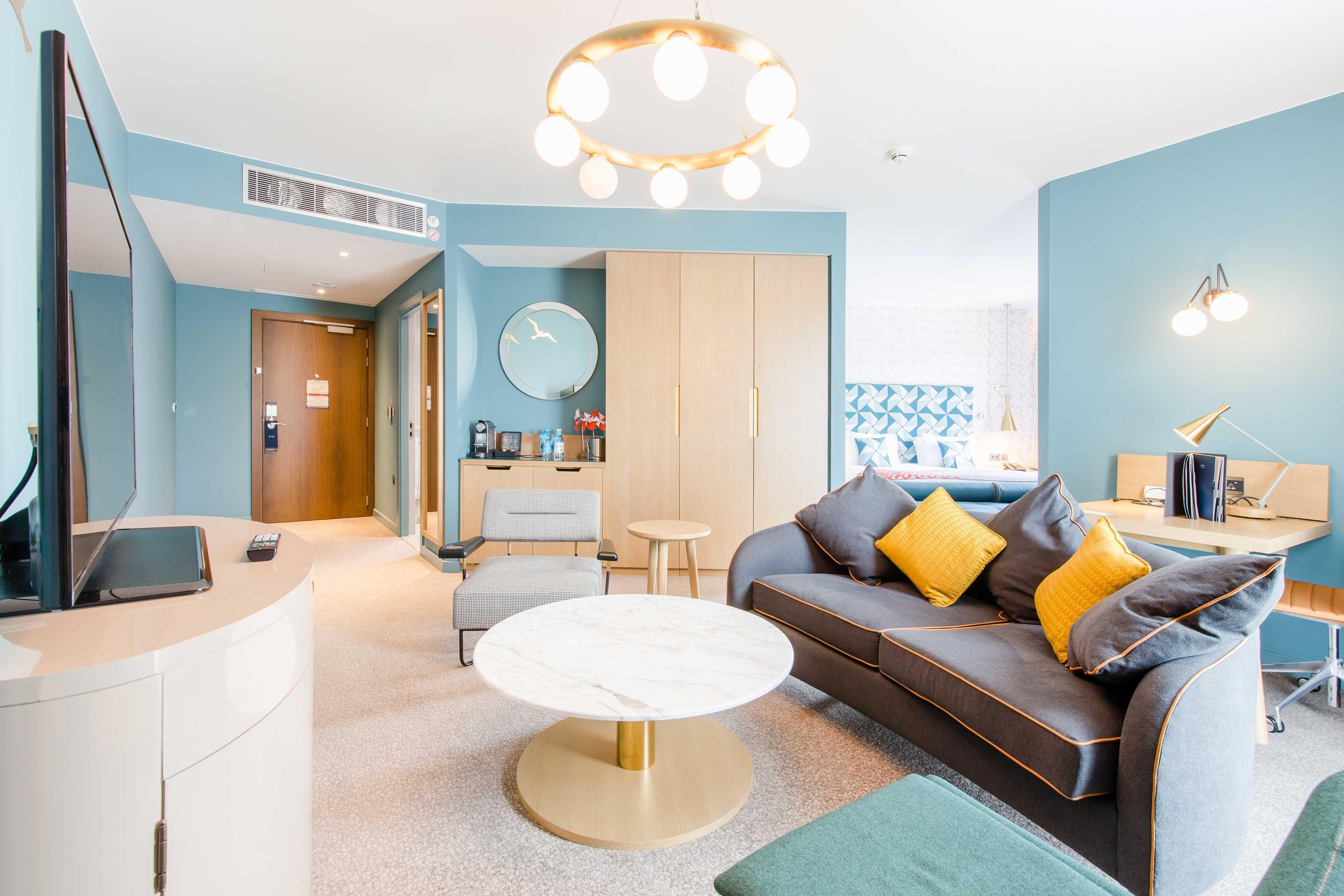 A modern living room with a sofa, coffee table, and a dining area.