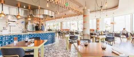 A restaurant with a central bar area, multiple dining tables, and a patterned floor.