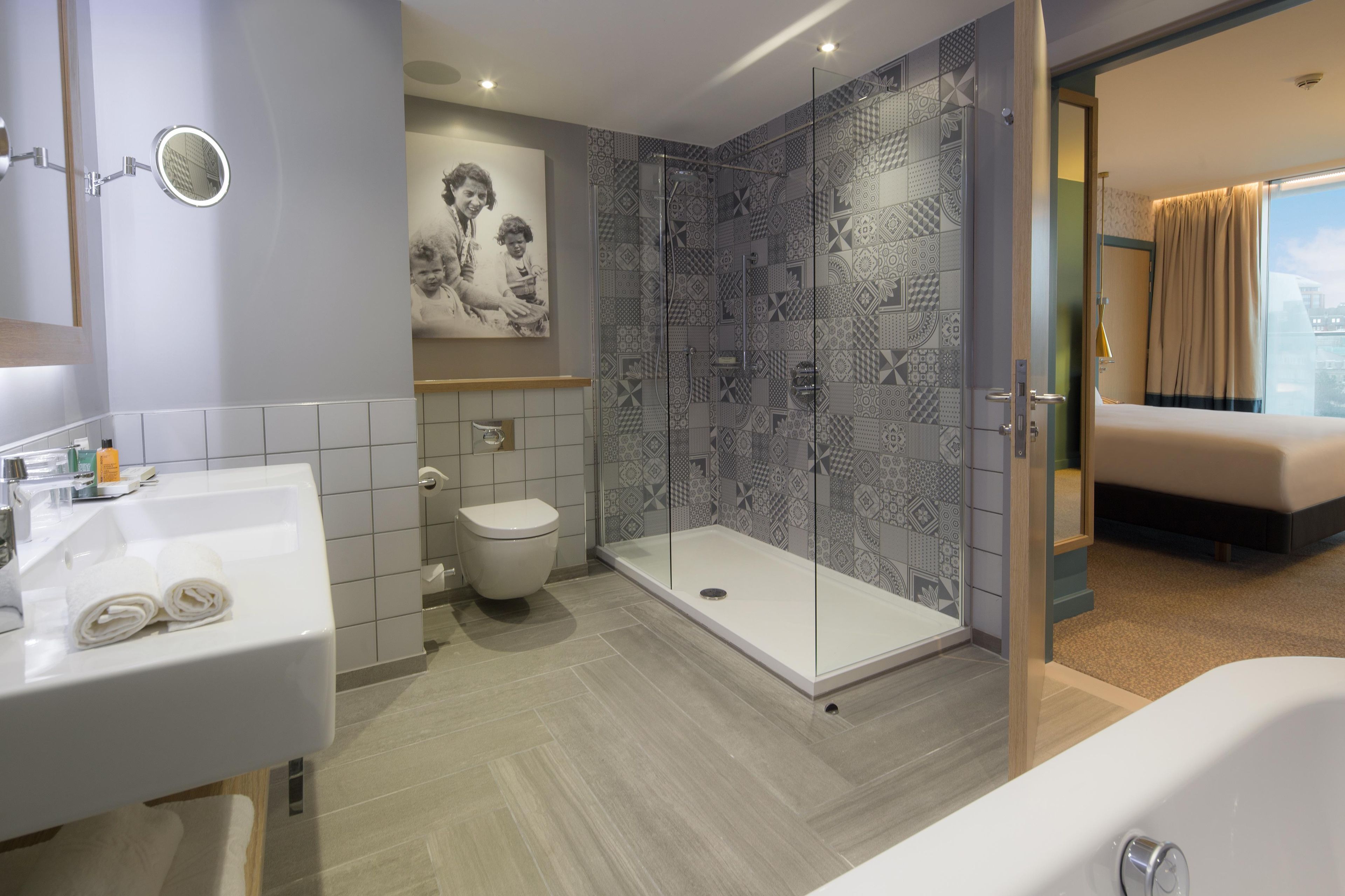 A modern bathroom with a shower, toilet, and sink.