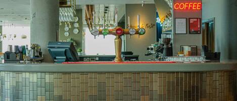 Eine Bar mit einer Theke, einem leuchtenden Neon-Schild mit der Aufschrift 'The Bar' und einem Schild für Kaffee.