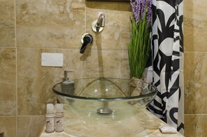 A bathroom with a glass bowl sink, a faucet, a towel rack, and a shower curtain. - Cusco Bed and Breakfast (Cusco)