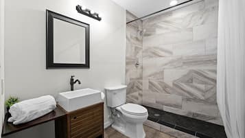 Deluxe suite | Badkamer | Een douche, handdoeken, zeep, shampoo