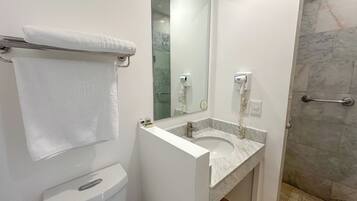 A modern bathroom with a toilet, sink, and shower.