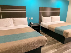 Two beds with headboards, a bedside table with a phone, and a wall socket. - Motel 6 Houston, TX - Hwy 249 and Fallbrook (Houston)