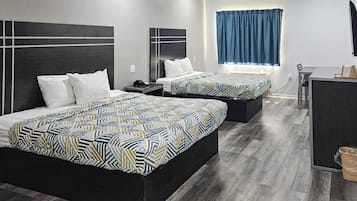Una habitación de hotel con dos camas, un escritorio y una ventana con cortinas.